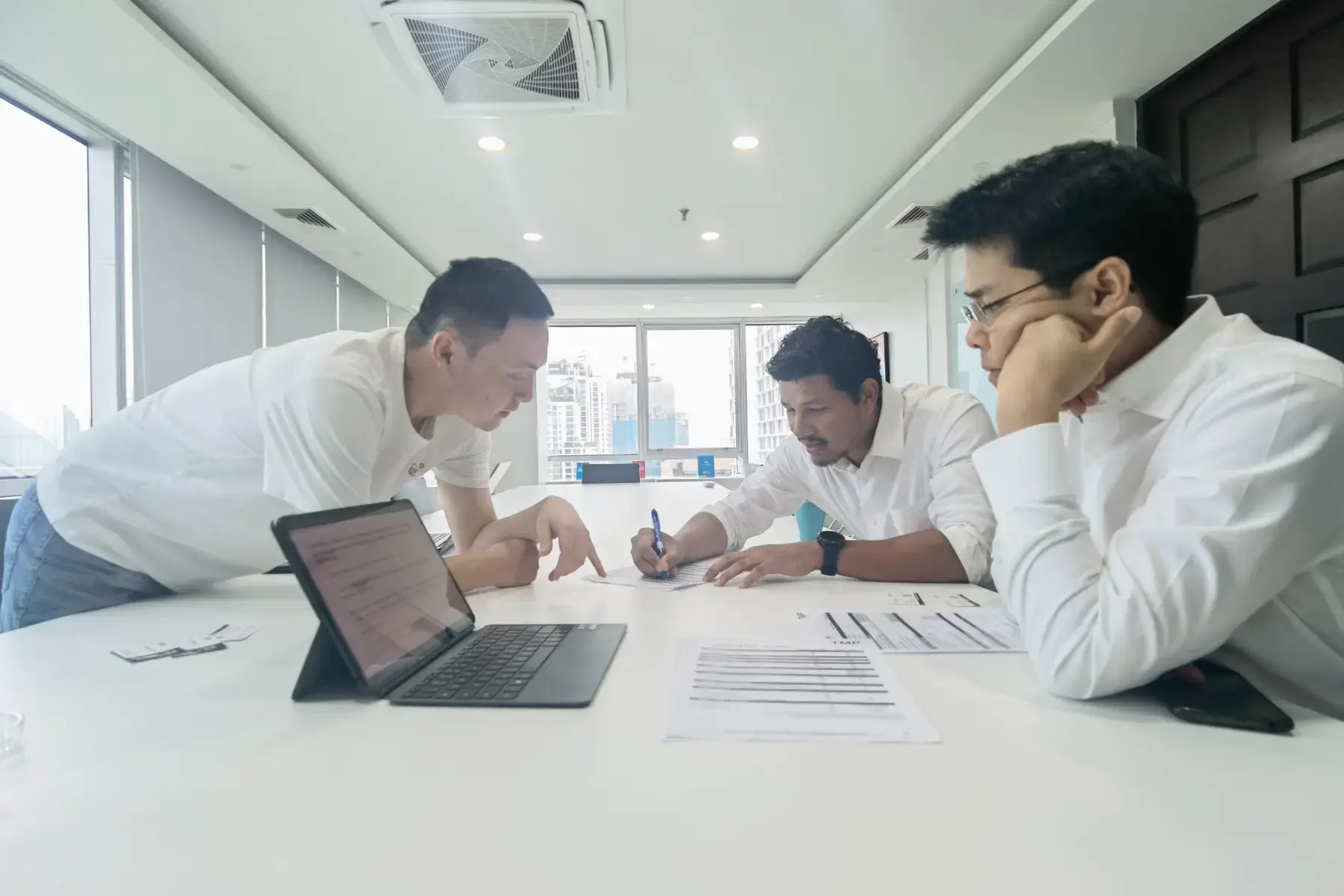 Three people reviewing materials during a working session